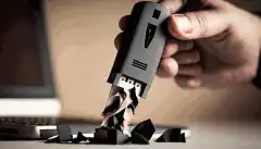 Image d'une personne tenant une clé USB avec une déchiqueteuse en arrière-plan
